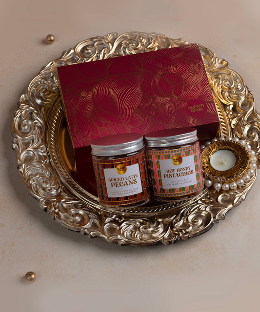 Two small jars on a decorative silver tray with a red card on a beige background. 
Trays and Platters. Luxury Gifting. Bespoke Diwali gift. Thoughtful gifts. No Nasties. Clean Ingredients. UAE. Dubai. Abu Dhabi. Sharjah. Delivery throughout UAE. Nuts. Nut Butters