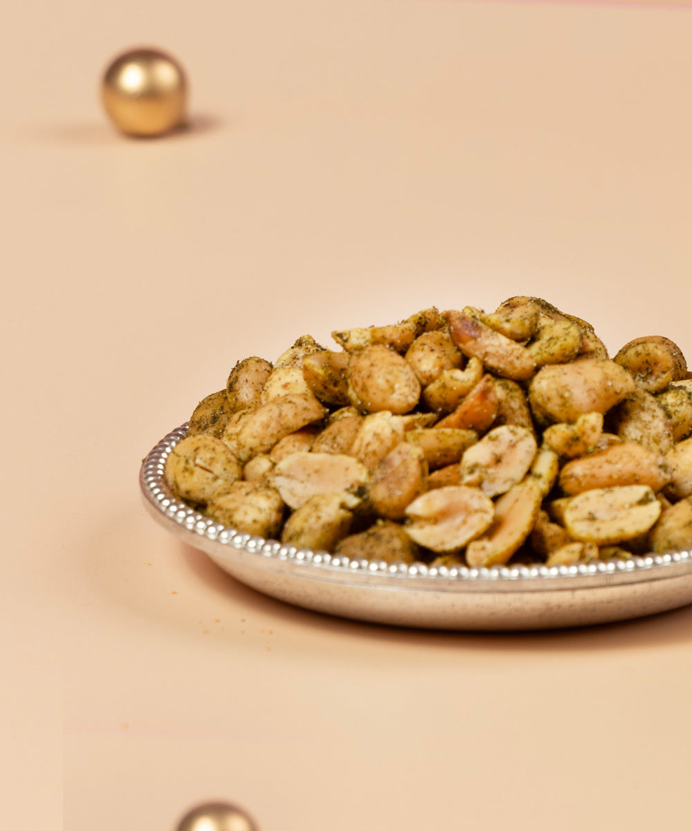 Peanuts in a decorative bowl on a beige background. Jar of chutney peanuts with a label on a beige background. Bespoke Diwali gift. Thoughtful gifts. No Nasties. Clean Ingredients. UAE. Dubai. Abu Dhabi. Sharjah. Delivery throughout UAE. Nuts. Nut Butters. HeartiGrub
