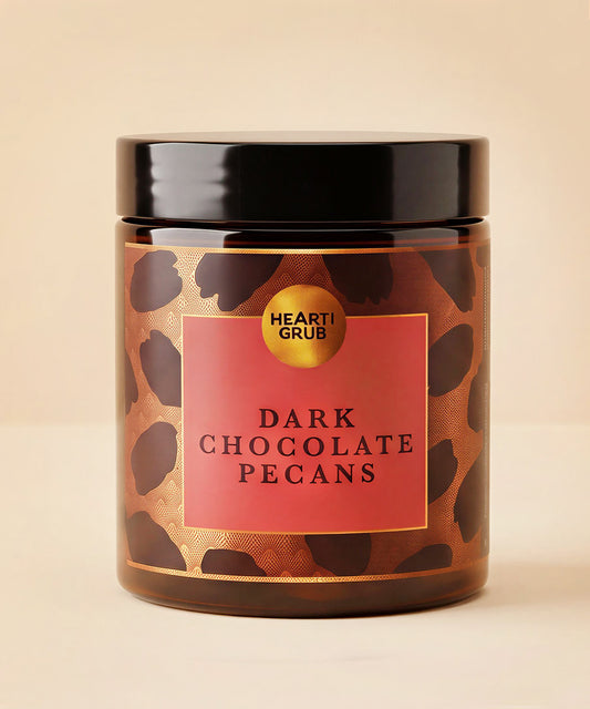 Dark Chocolate pEcans. Nuts. Chocolate Treats. Diwali gifts. Eid Gifts. Corporate Gifts. HeartiGrub. Abu Dhabi. Hearti Grub. Dark Chocolate Pecans candle in a clear glass jar with a black lid, featuring a brown and black leopard print pattern with a red label.