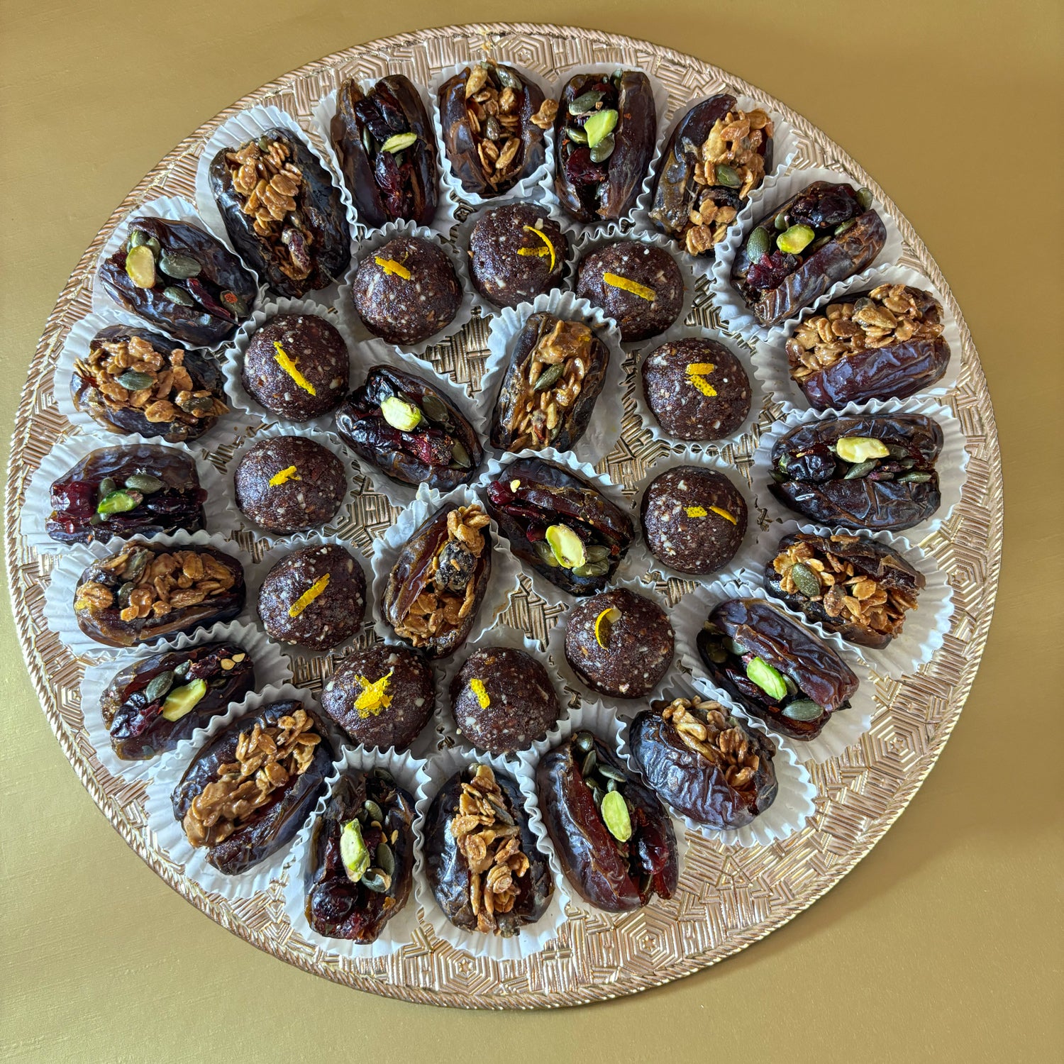 Delivery throughout UAE. Ramadan and Eid Gifting. Dates Platter. Made locally by HeartiGrub. Luxury Gifting. Organic and Healthy. Ramadan and Eid Gifting. Dates Platter. Made locally by HeartiGrub. Luxury Gifting. Organic and Healthy. HeartiGrub Dates and Truffle Ball Platter featuring granola almond butter and cranberry pistachio filled Medjool dates with hazelnut orange truffle balls, a premium Ramadan and Eid gift hamper.