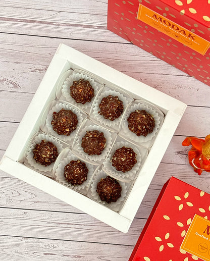 Gift set with Modak, Ganesh Chaturthi items, and a yellow ribbon on a wooden surface. Ganesh Chaturthi. Gifting. Made in Small Batches. Deliciously Decadent. Vegan Gluten Free Refined Sugar Free. Delicious Modak. Nuts. Delivery throughout U.A.E. HeartiGrub