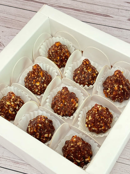 Gift set with Modak, Ganesh Chaturthi items, and a yellow ribbon on a wooden surface. Ganesh Chaturthi. Gifting. Made in Small Batches. Deliciously Decadent. Vegan Gluten Free Refined Sugar Free. Delicious Modak. Nuts. Delivery throughout U.A.E. HeartiGrub