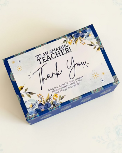 HeratiGrub Gift Hamper for Teachers Day. Delivery throughout the UAE. Gift box with 'Thank You' card for an amazing teacher on a textured surface.