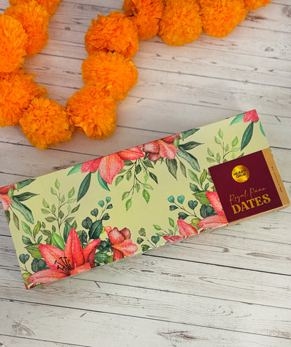 Jumbo Medjool. Royal Paan Khajur dates. No nasties. Gift set with Modak, Ganesh Chaturthi items, and a yellow ribbon on a wooden surface. Ganesh Chaturthi. Gifting. Made in Small Batches. Deliciously Decadent. Vegan Gluten Free Refined Sugar Free. Delicious Modak. Nuts. Delivery throughout U.A.E.