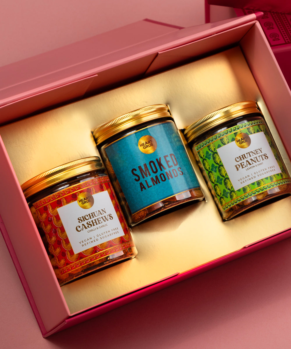 Bespoke Diwali gift. Thoughtful gifts. No Nasties. Clean Ingredients. UAE. Dubai. Abu Dhabi. Sharjah. Delivery throughout UAE. Nuts. Nut Butters. Three jars of nutsin a pink 'Hearti Grub' box on a pink background for Diwali Gifting. 