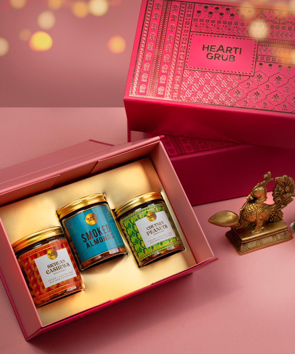 Bespoke Diwali gift. Thoughtful gifts. No Nasties. Clean Ingredients. UAE. Dubai. Abu Dhabi. Sharjah. Delivery throughout UAE. Nuts. Nut Butters. Three jars of nutsin a pink 'Hearti Grub' box on a pink background for Diwali Gifting. 